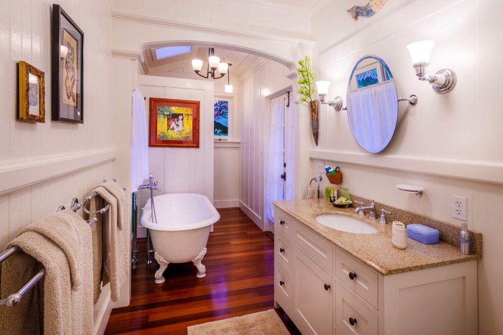lovely bathroom with clawfoot bathtub and sink with wooden floors