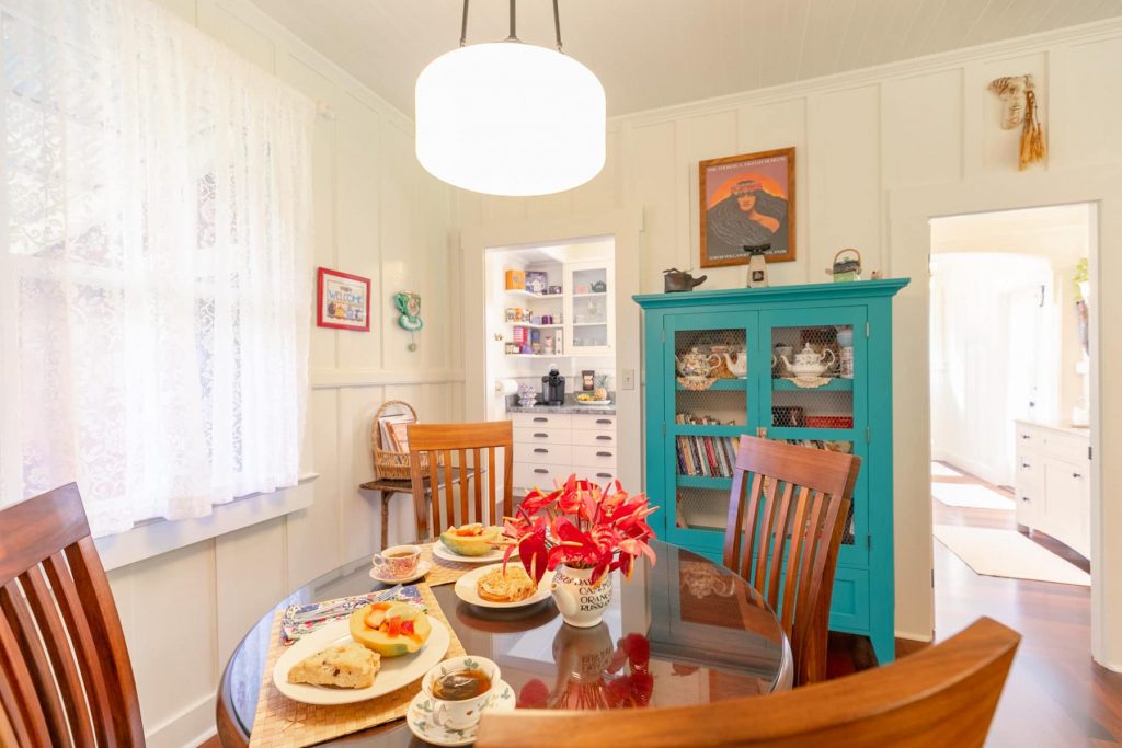 dining area with lovely food on the table. a blue hutch filled with books and teapots.
